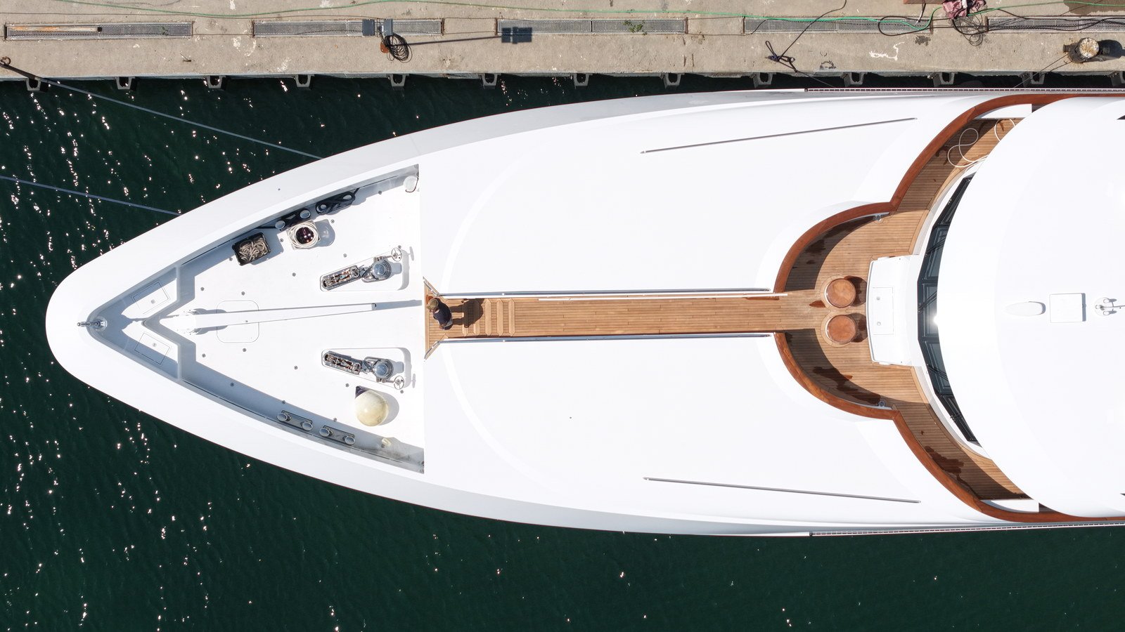 Plan view of a superyacht foredeck showing the teak walkway and king plank, twin windlasses, mooring fittings and flush deck hatches set into the white deck