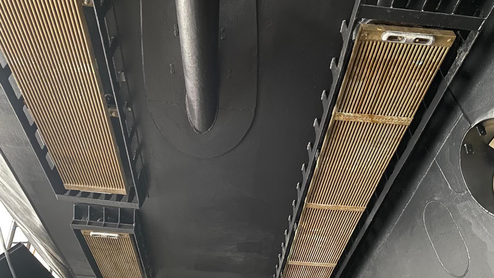 Two sea chest gratings set into the hull bottom either side of the shaft bossing, seen from below with the yacht ashore.